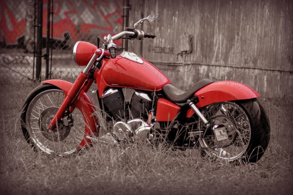 Design and style. Red bike, motorcycle on the background of a fence