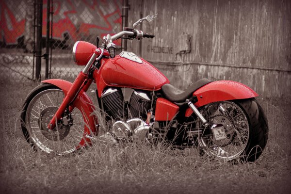 Diseño y estilo. Bicicleta roja, moto en el fondo de la valla