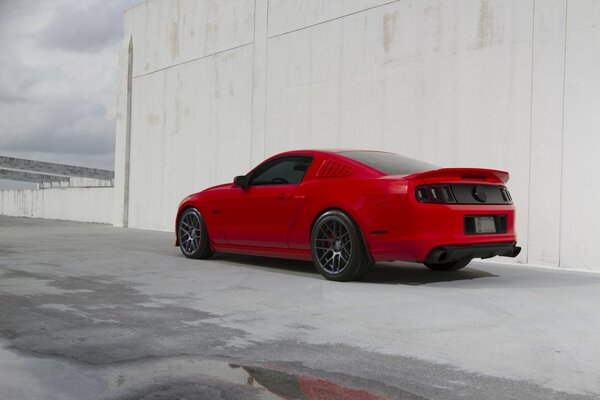 Red Ford near the wall, rear view