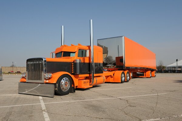 Большой ораньжевый грузовик на асфальте