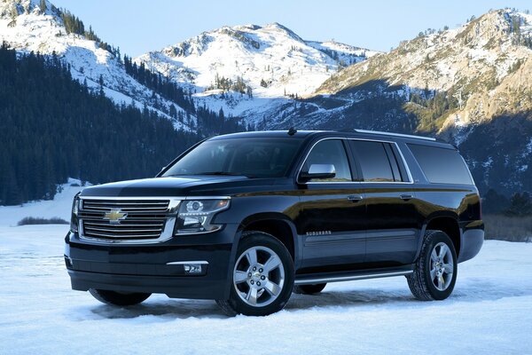 Un chevrolet negro está parado en la nieve