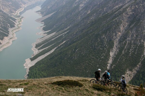 Ciclisti sul pendio bellissimo fiume lungo natura