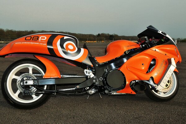 Motocicleta Suzuki naranja en la pista