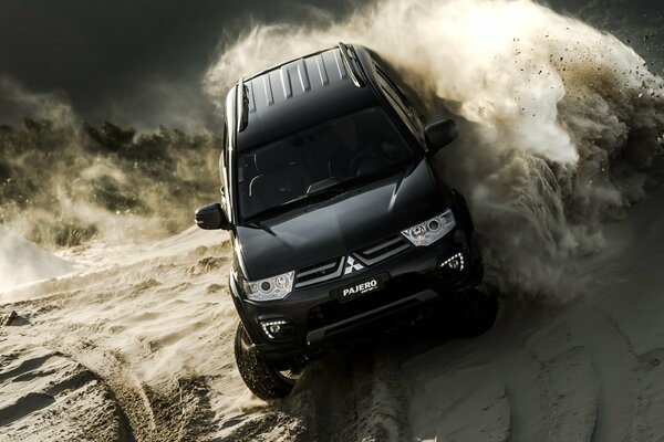 Mitsubishi Pajero nero sulla sabbia nei club di polvere