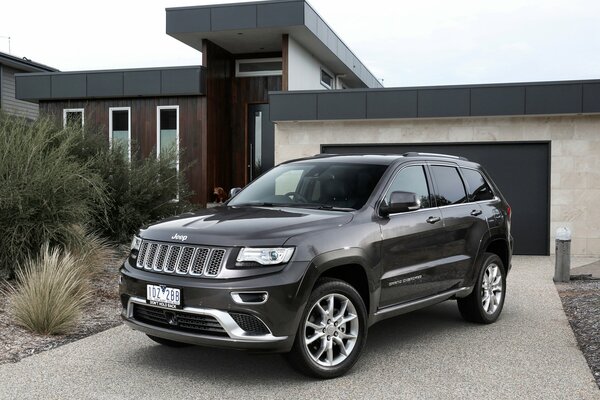 Der schwarze Jeep des Grand Cherokee ist vor dem Haus geparkt