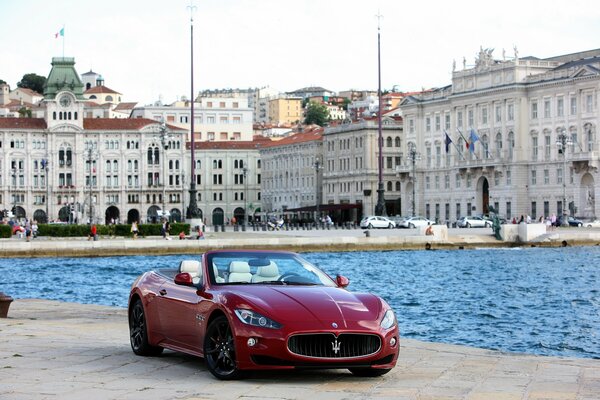 Red maserati on the background of a beautiful city