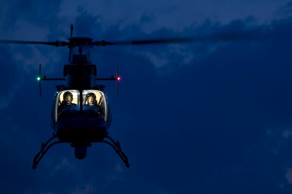 Elicottero con cabina di pilotaggio illuminata sospeso in aria