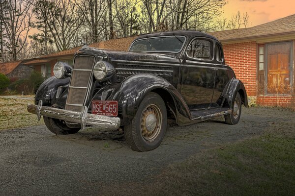 Voiture rétro Dodge coupé 1935 sur fond de maison de briques rouges