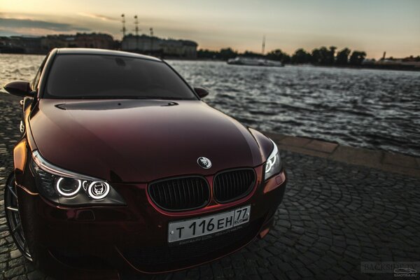 Burgundy beauty bmw m5 on the embankment