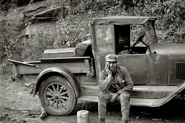 Schwarz-Weiß-Foto eines Arbeiters in der Nähe eines Lastwagens