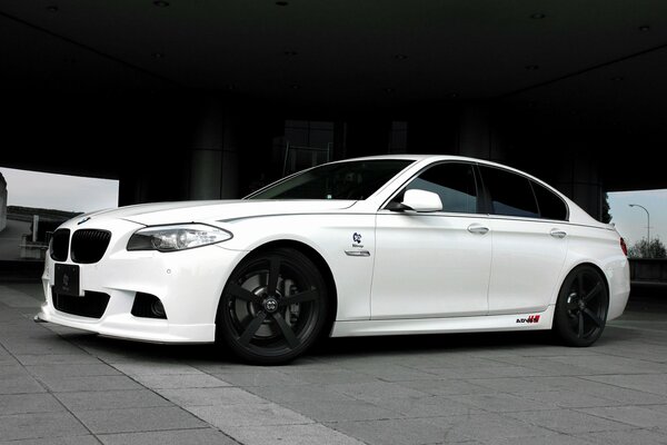 White BMW on paving slabs