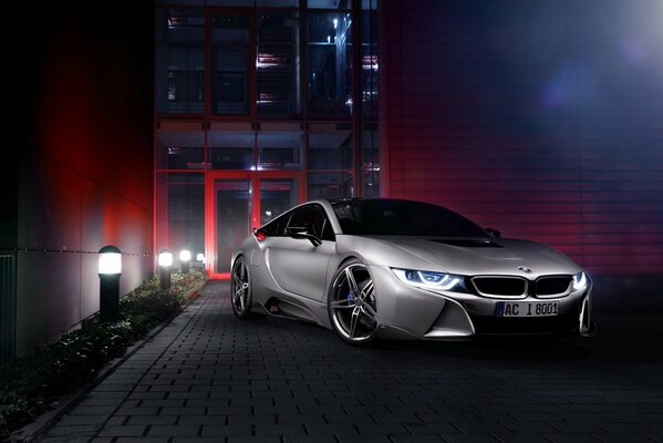 BMW i8 in grey on the background of a building with red backlight