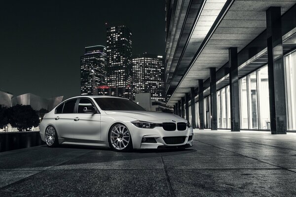 BMW blanco en las luces de la ciudad nocturna