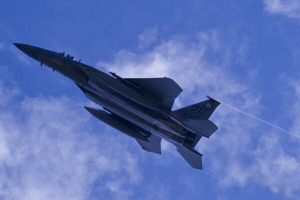 A military fighter is gaining altitude in a cloudy sky