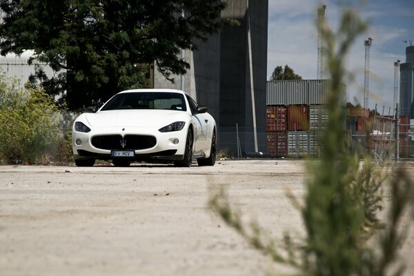 White Maserati on the side of a dirt road