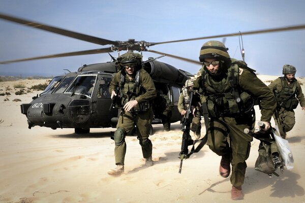 Landing of soldiers from a helicopter in the desert