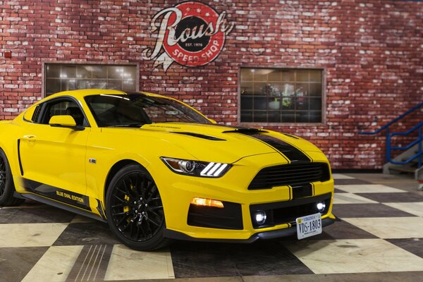 Gelber Ford Mustang auf Backsteinmauer Hintergrund