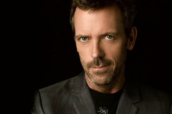 Dr. House: inimitable look, unshaven, dark suit