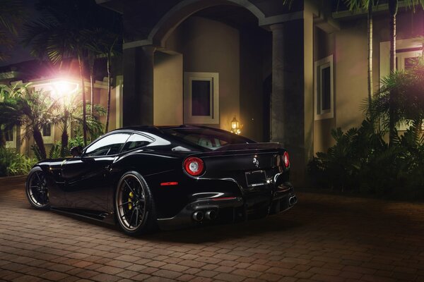 Schwarzer Ferrari nachts in der Nähe des Hauses