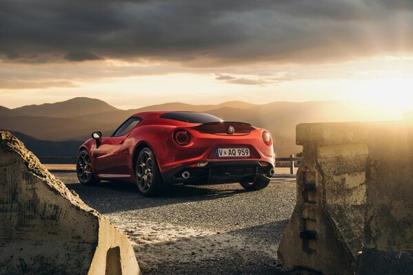 Czerwona Alfa Romeo eskortuje Zachód słońca