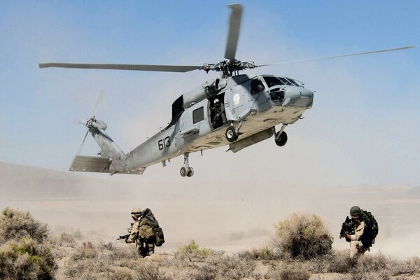 Hélicoptère au-dessus du sol et soldats en fuite