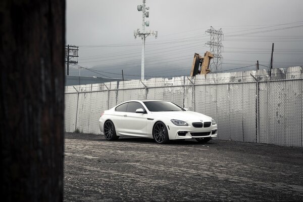 Coche BMW blanco en el fondo de la valla
