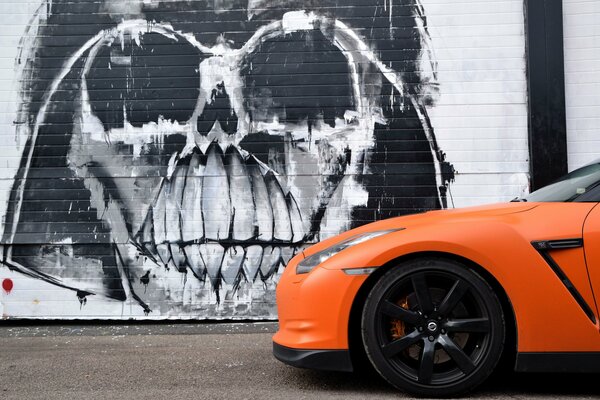 Orange Nissan auf Graffiti-Hintergrund