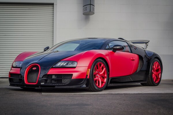 Roter Bugatti Veyron reitet langsam auf einem Stein