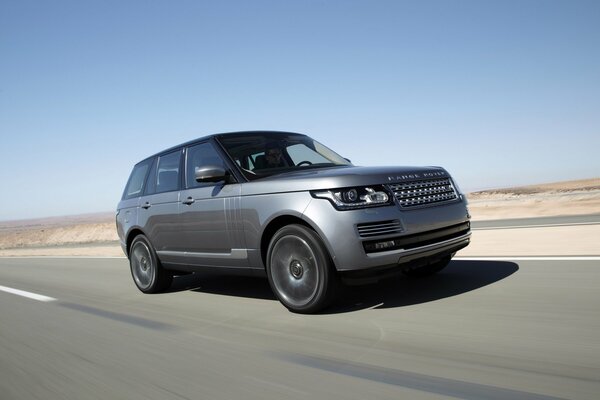 Range Rover paseo rápido por la pista en el desierto