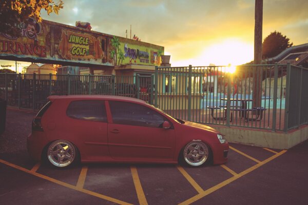 Rojo Volkswagen Golf en el fondo de la puesta de sol