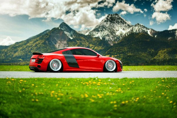 Red audi drives through the mountains