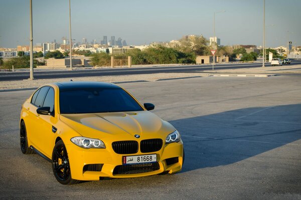 Yellow BMW. Bright car in the city