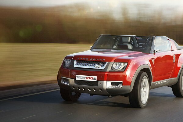 Roter Land Rover rast mit hoher Geschwindigkeit