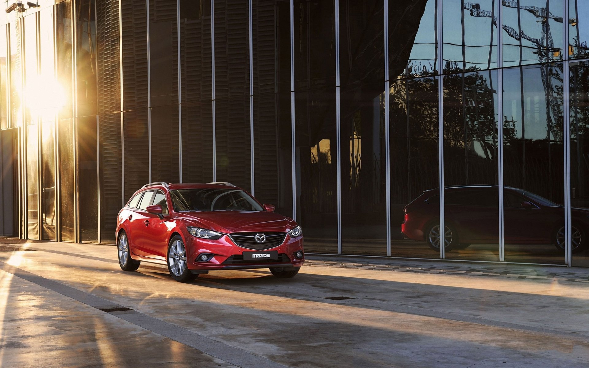 mazda wagon mazda six red.front building sun background