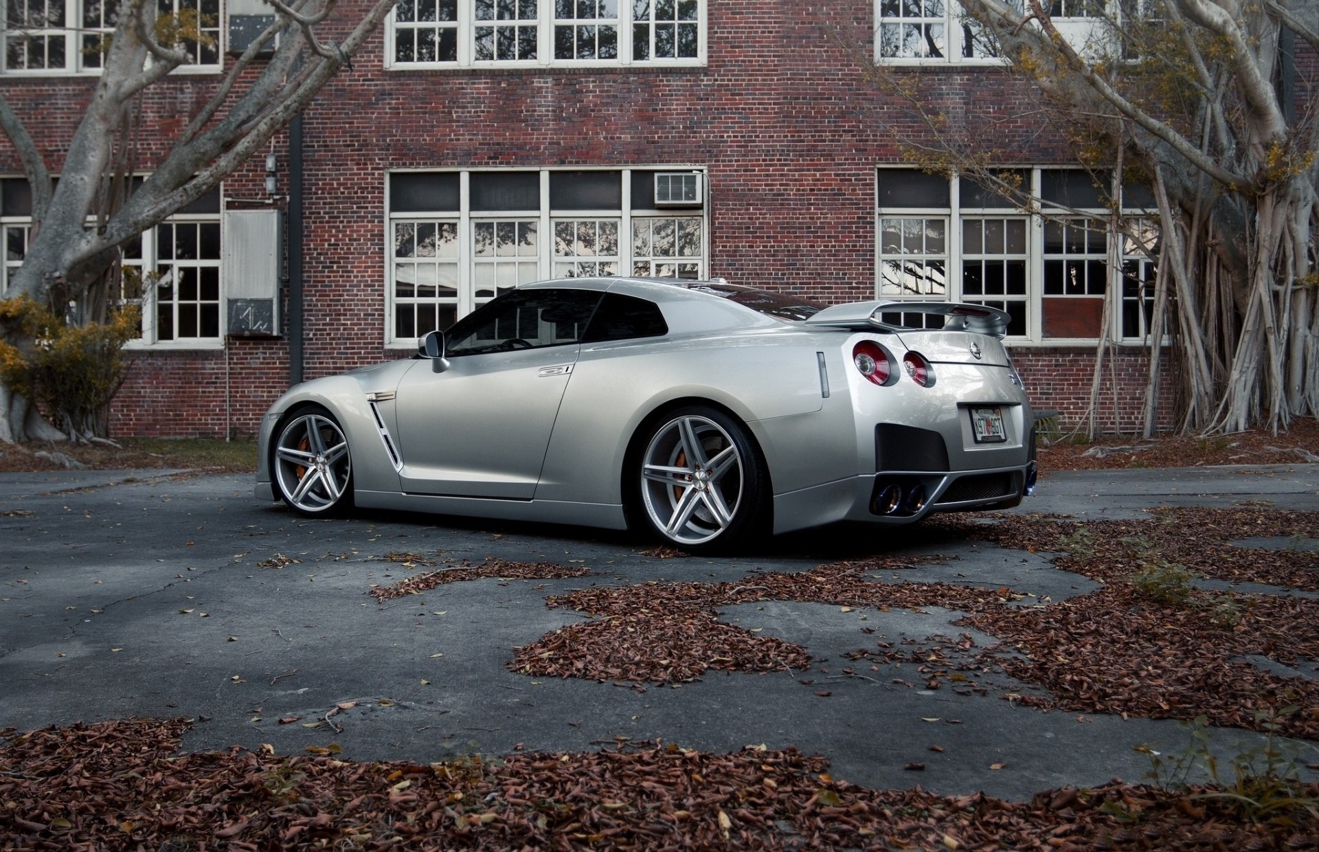 teinte feuillage spoiler nissan brouette arbres jantes asphalte bâtiment route voiture pare-chocs fenêtre auto gris