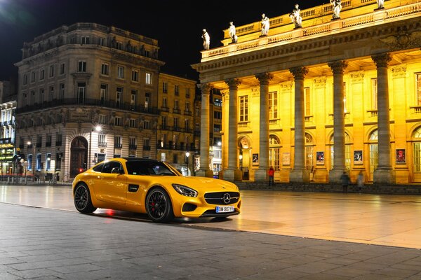 Supercar coloré jaune sur la place de la nuit