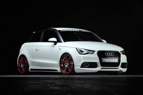 Luxusauto der Marke Audi in weißer Farbe auf schwarzem Hintergrund
