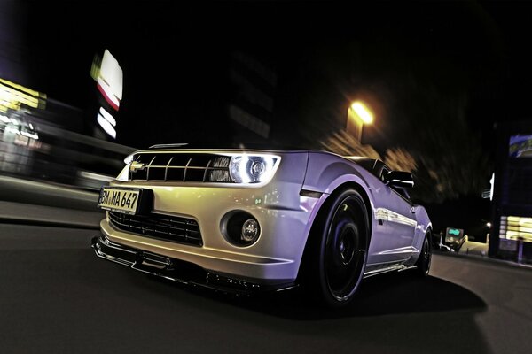 Picture of a chevrolet camaro car in a night city photo from the front