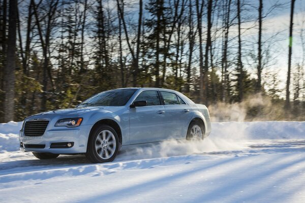 Chrysler leci po zaśnieżonej leśnej drodze