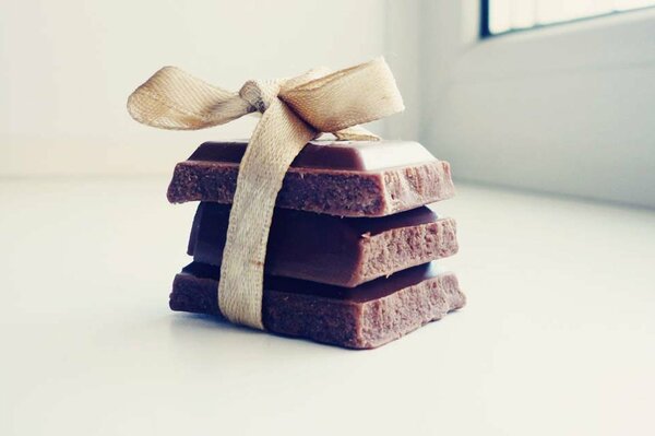 A slide of chocolate on the windowsill with a bow