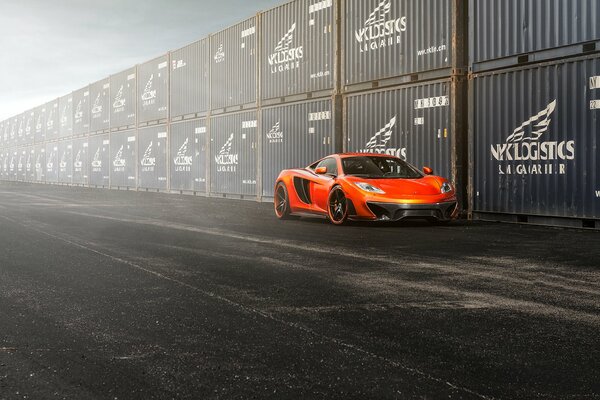 On the background of the fence - a bright scarlet sports supercar