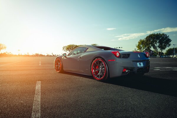 Ferrari mit roten Rädern vor dem Hintergrund der Sonne