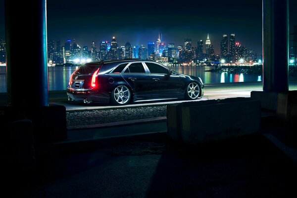 Cadillac negro en el fondo de la ciudad de la noche