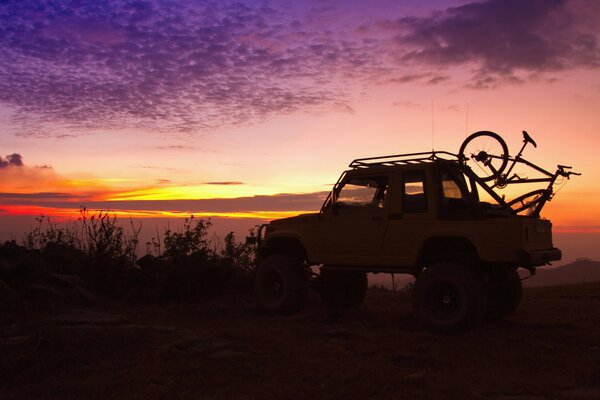 Silhouette image of an SUV on a beautiful background