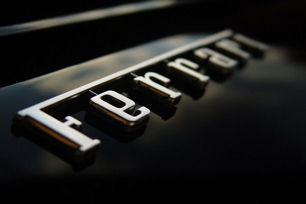 Silver Ferrari logo on a black car