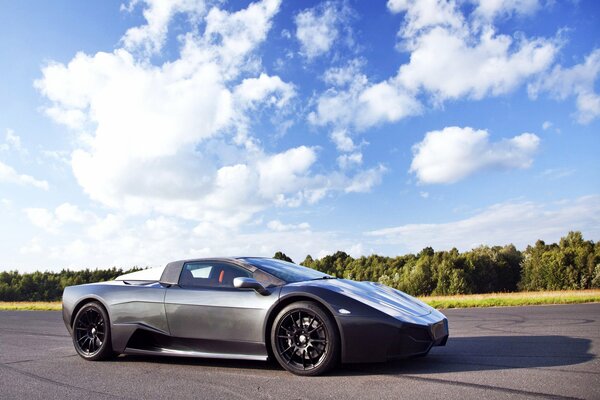 Supercar sur le circuit COGECO. Fond de forêt et ciel bleu