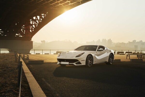 White Ferrari under the bridge at sunset