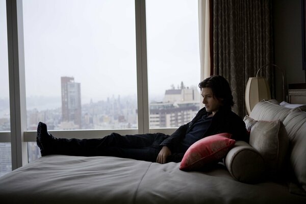 Schauspieler Ben liegt auf dem Bett mit Blick auf die Stadt