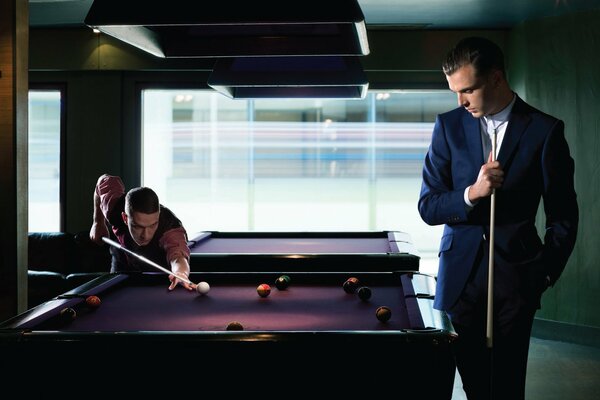 Men enthusiastically play billiards