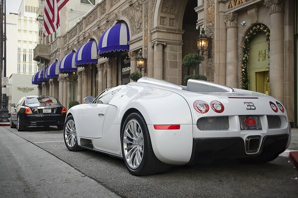 A white buggati is parked near the building